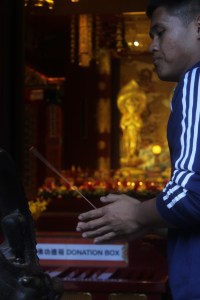 A Buddhist prays at Singapore's Tooth Relic Temple & Museum. Incense is ultimately associated with prayer rituals here. 