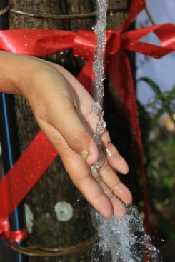 Water splashes down and trickles off Rodiah's hand.