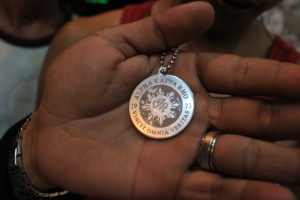 A symbol of brotherhood. A silver medallion necklace of AKP 73, which was heated up and burned into Adz's and other members' arms when they were initiated into the gang-frat. 