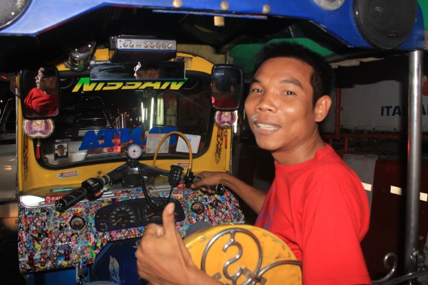 A Bangkok tuk tuk driver gives a big grin after a long drive through the Bangkok streets. Tuk tuks are the primary medium of transport here.