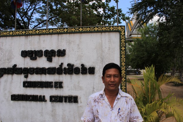Run Phyros, a Khmer Rouge survivor, stands outside the Killing Fields or Choeung Ek where countless Cambodians were executed. 