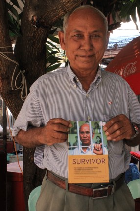 One of three living survivors to escape the clutches of Tuol Sleng prison, Chum Mey sells his book at the facility's gates.